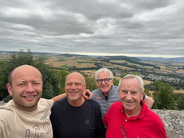 Vier Vereinsmitglieder vor dem Blick ins Tal von der Burgruine Heiligenberg